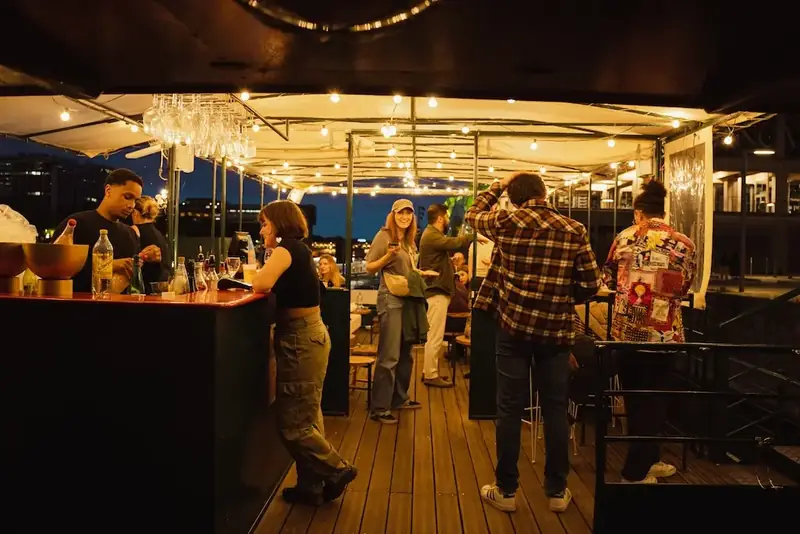 Le bar en bois sombre, bien rempli en soirée