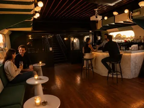 Le bar intérieur et son comptoir clair, quelques invités autour des tables hautes