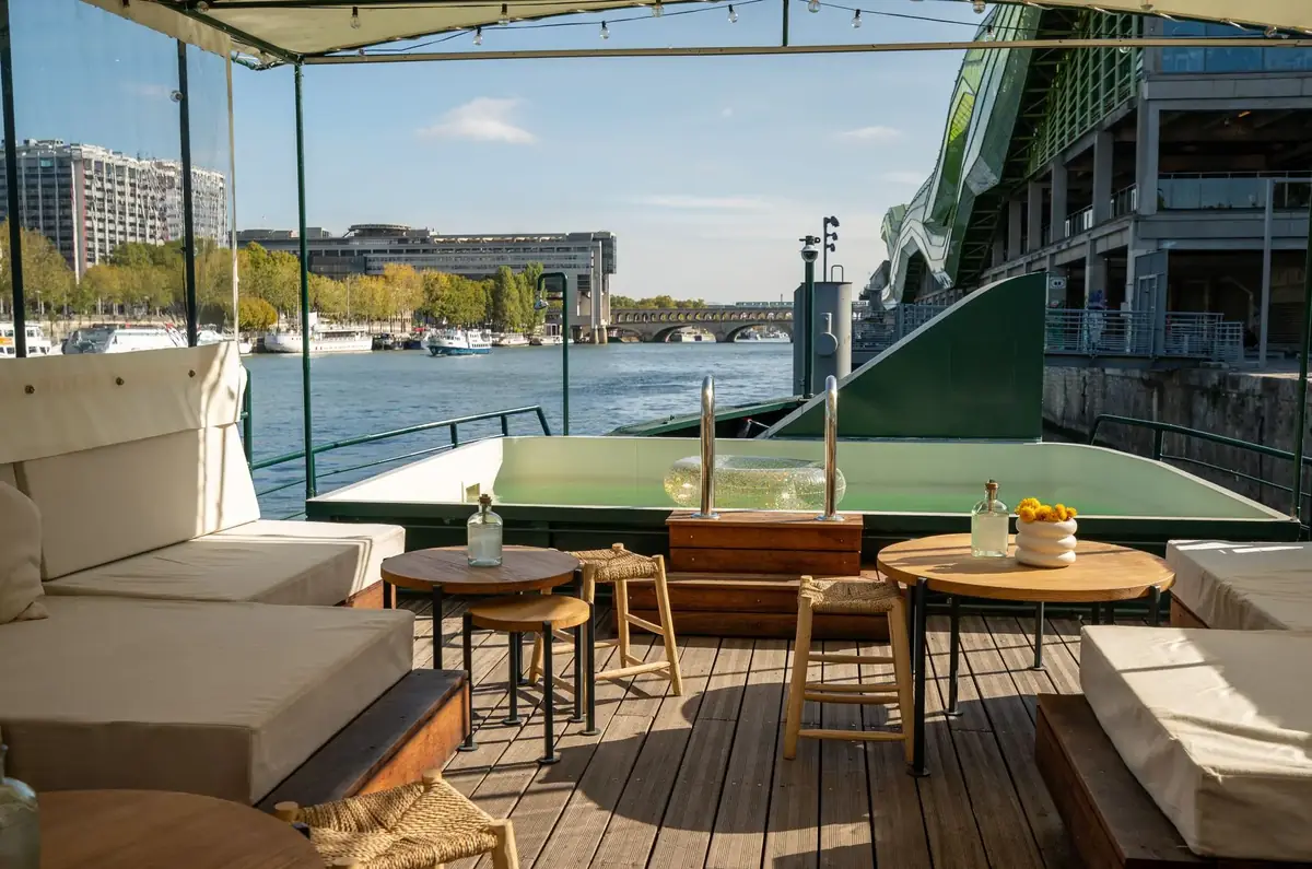 Le bassin vert de la piscine, bordé de banquettes et de tables basses