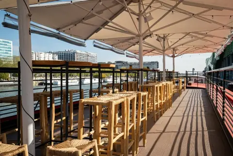 La terrasse du quai aménagée de mange-debout et de parasols, avant l'arrivée des invités