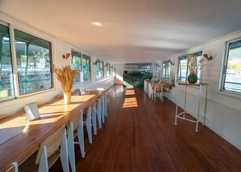 La salle restaurant, longue table dressée le long des fenêtres