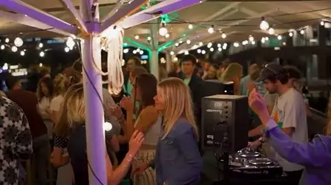 Soirée sur le toit-terrasse, éclairage coloré et invités debout
